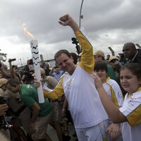 Riot police disperse protesters with tear gas as Olympic torch-bearer moons crowd in Rio