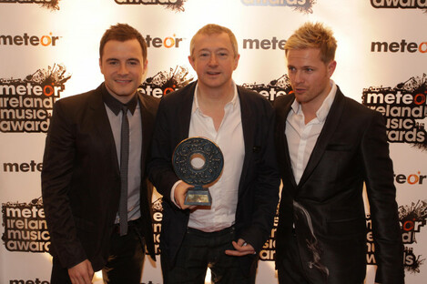 Shane Filan (L) and Nicky Byrne (R) of Westlife with manager Louis Walsh (centre) at the Meteor Music Awards in 2009. 