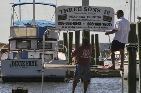 Boat renters take down their sign in Biloxi, Mississippi as residents brace for the arrival of the storm