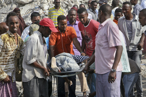 Somalis remove the body of a man killed in the blast. 