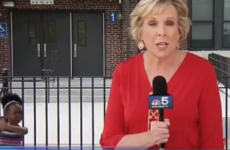 Little girl dances in the background of news report