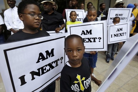 Alvin Duplessis, 10, left, and Thomas McGriff, 5, foreground, hold signs with others from the Watson Memorial Teaching Ministries Church of New Orleans, at a rally held in reaction to the recent George Zimmerman acquittal in New Orleans.