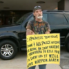 Man forced to hold 'IDIOT' sign outside police station