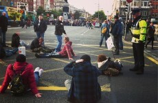 Protesters sit down and block cars on O'Connell Bridge and the Quays
