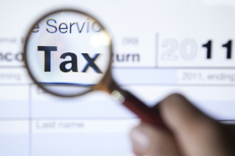 Magnifying glass over the word tax on a form