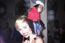 Miley Cyrus poses with a monkey dressed as a cowboy on her back