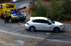 Tow truck driver watches helplessly as car rolls downhill