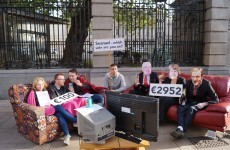 Students protest cuts to social welfare by eating beans on a couch at Leinster House