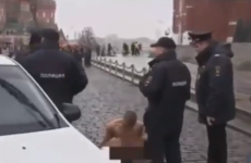 Russian artist strips naked and nails his testicles to a cobblestone in Red Square