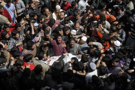 Kashmiri Muslims shout slogans as they crowd around the body of Moulvi Showkat Ahmed Shah