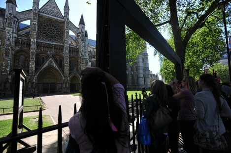 Tourists take photos of the exterior of Westminster Abbey. There will be nothing to stop guests doing the same inside the Abbey tomorrow