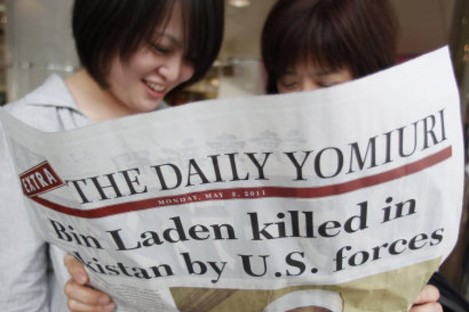Women reads the extra edition of a Japanese newspaper in Tokyo Monday, May 2, 2011, reporting the death of Osama bin Laden. 