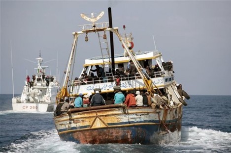 In this photo provided by the Italian Coastguard, a boat reportedly carrying 760 migrants is escorted to the Lampedusa harbor, Italy, Tuesday, April 19, 2011.
