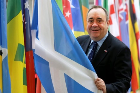 Scotland's First Minister Alex Salmond views a saltire flag at Glasgow Airport.