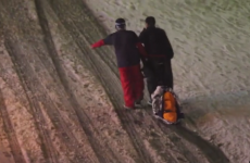 Two guys helping their drunk friend get home in a ski resort