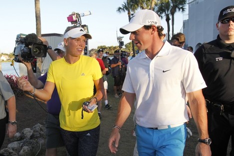 Rory McIlroy walks with his fiancee, tennis player Caroline Wozniacki, after finishing his third round at the Honda Classic 