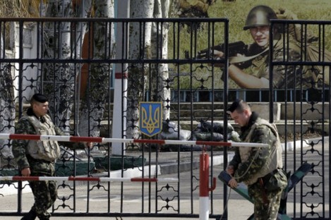 Ukrainian soldiers stand guard at the gate of a military base in the port of Kerch in Crimea.