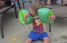 Cute kid learns it's very difficult to eat with arm bands on