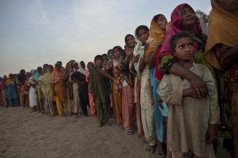 Pakistanis line-up during an aid distribution by the United Nations World Food Program at a camp for families displaced by floods 