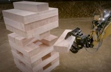 Guys play massive game of Jenga using heavy machinery