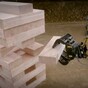 Guys play massive game of Jenga using heavy machinery