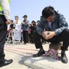 Race to recover bodies from Korea ferry before storms hit