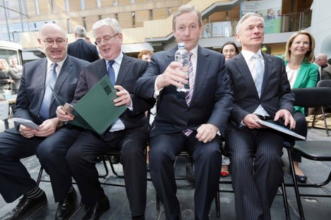 Enda Kenny with a timely bottle of water and flanked by Phil Hogan, Eamon Gilmore and Richard Burton in Mullingar today 