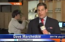 Guy drinks from a vase of flowers in weirdest photobomb ever