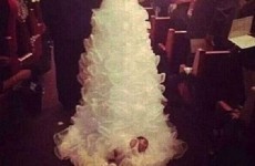 Bride walks down aisle with newborn baby attached to her dress
