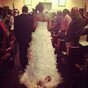 Bride walks down aisle with newborn baby attached to her dress