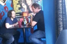 Just Quentin Tarantino having lunch under a Pulp Fiction poster