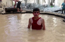 In Syria, children swim in craters made by barrel bombs