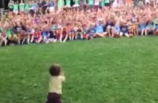 Toddler adorably conducts cheering crowd