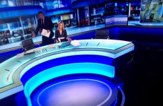 Dobbo makes an awkward dash for his chair on the Six One News