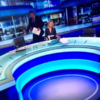 Dobbo makes an awkward dash for his chair on the Six One News