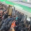 Passengers use collective strength to push train off trapped man