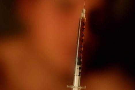A drug addict holds up a heroin needle (File photo)