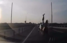 Motorcyclist in insane front-flip crash lands feet-first on roof of moving car
