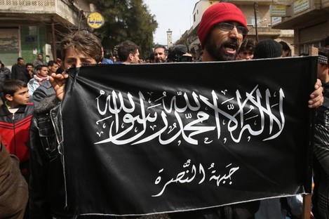 In this file photo, anti-Syrian President Bashar Assad protesters hold the al-Nusra flag.