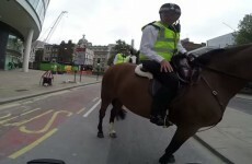 Guy doing a wheelie on a motorbike gets rightly scolded by a policeman on a horse