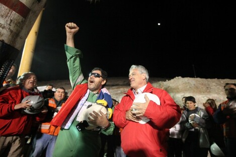 Luis Urzua (left), the last of the miners to be rescued, sings the national anthem with Chilean president Sebastian Pinera.