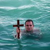 Orthodox Christians dive into ice-cold waters to chase wooden crosses
