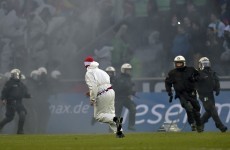 Cologne pitch invaders wearing boiler suits clash with police and rival fans in Rhine derby