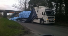 Lorry tries to make it under low bridge: Doesn't make it