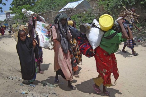 Somalis from southern Somalia carrying their belongings make their way to the refugee camp in Mogadishu