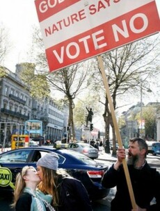 A photographer captured two girls defiantly kissing in front of a No protester