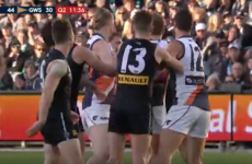 Aussie Rules player sneaks in for a goal while everyone else watches a scrap
