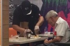 'The cashier came out of the kitchen, sat down, and began helping the man to eat'