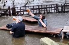 These two guys just kept on drinking even though the pub's beer garden was flooded