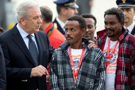 European Commissioner for Migration and Home Affairs Dimitris Avramopoulos, left, speaks to Eritrean refugees waiting to board an Italian aircraft that will take them to Sweden, at Rome's Ciampino airport in October.